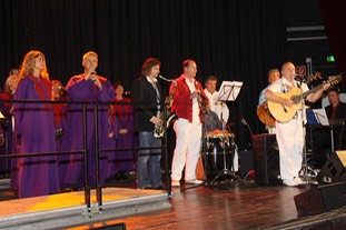die Salsaband "Tumbao" um Kai Heumann mit dem Saxophonisten Jens Streifling von der Kölner Band "Die Höhner" und dem Livinggospel Chor. Der Chor ist in lila gekleidet.
